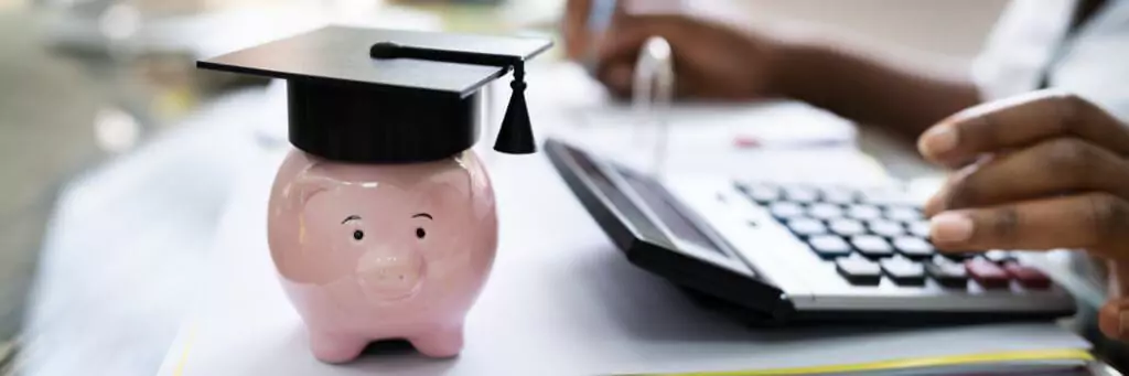 moça fazendo contas em calculadora com cofrinho ao lado usando capelo