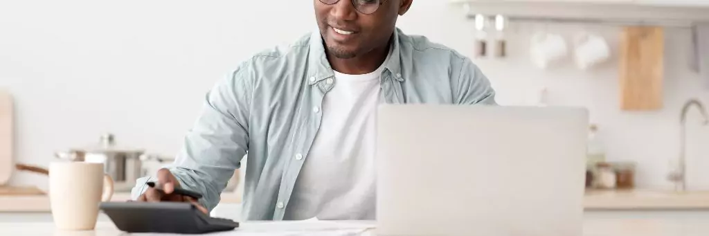 homem fazendo contas em calculadora