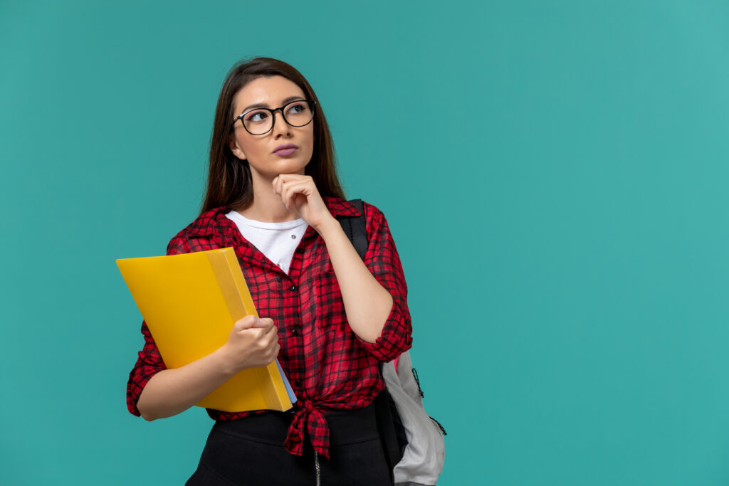 Estudante com mochila e pastas, pensativa
